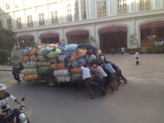 8 men needed to push a ton of denim clothing from the Cambodian to the Thai border crossing.